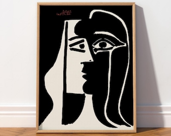 May include: A framed art print featuring a high-contrast black and white abstract portrait. The image displays a stylized face divided into two distinct sections with bold lines. The text Picasso 12.6.60 is visible in the upper left corner.