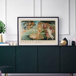 May include: A framed print of Sandro Botticelli's The Birth of Venus, a famous Renaissance painting depicting a nude woman emerging from a giant scallop shell. The painting is set against a backdrop of a blue sky and a green landscape.