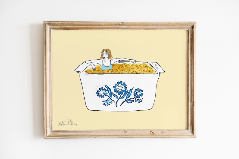 May include: A woman wearing sunglasses and a blue swimsuit is submerged in a white casserole dish with a blue floral design. The dish is filled with yellow pasta. The background is a light yellow color.