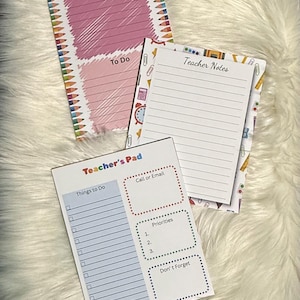 May include: Three notepads with different designs. One notepad has the words "Notes" and "To Do" with pink and white sections. Another notepad says "Teacher Notes". The third notepad says "Teacher's Pad" with sections for "Things to Do", "Call or Email", "Priorities", and "Don't Forget".