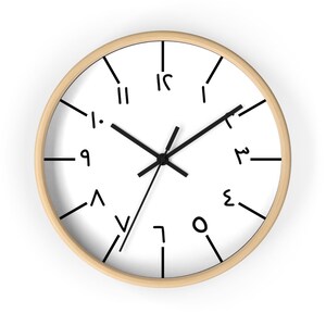 May include: A white clock with black hands and numbers. The numbers are written in a unique, handwritten style. The clock has a wooden frame.