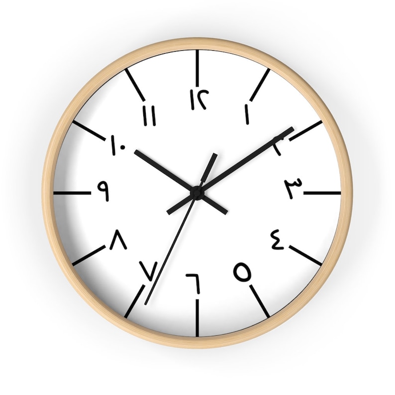 May include: A white clock with black hands and numbers. The numbers are written in a unique, handwritten style. The clock has a wooden frame.