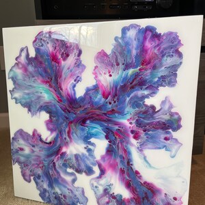 Puede incluir: Pintura abstracta sobre un lienzo blanco con colores p&uacute;rpura, rosa y azul que se arremolinan. Los colores se mezclan para crear un dise&ntilde;o &uacute;nico y org&aacute;nico.