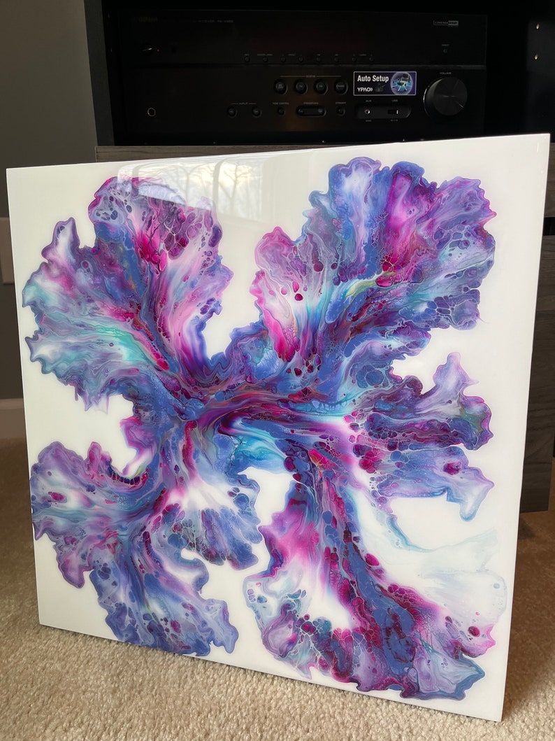 Puede incluir: Pintura abstracta sobre un lienzo blanco con colores p&uacute;rpura, rosa y azul que se arremolinan. Los colores se mezclan para crear un dise&ntilde;o &uacute;nico y org&aacute;nico.