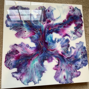 Puede incluir: Pintura abstracta sobre un lienzo blanco con un esquema de color morado, azul y blanco. La pintura se ha vertido y girado para crear un dise&ntilde;o &uacute;nico.
