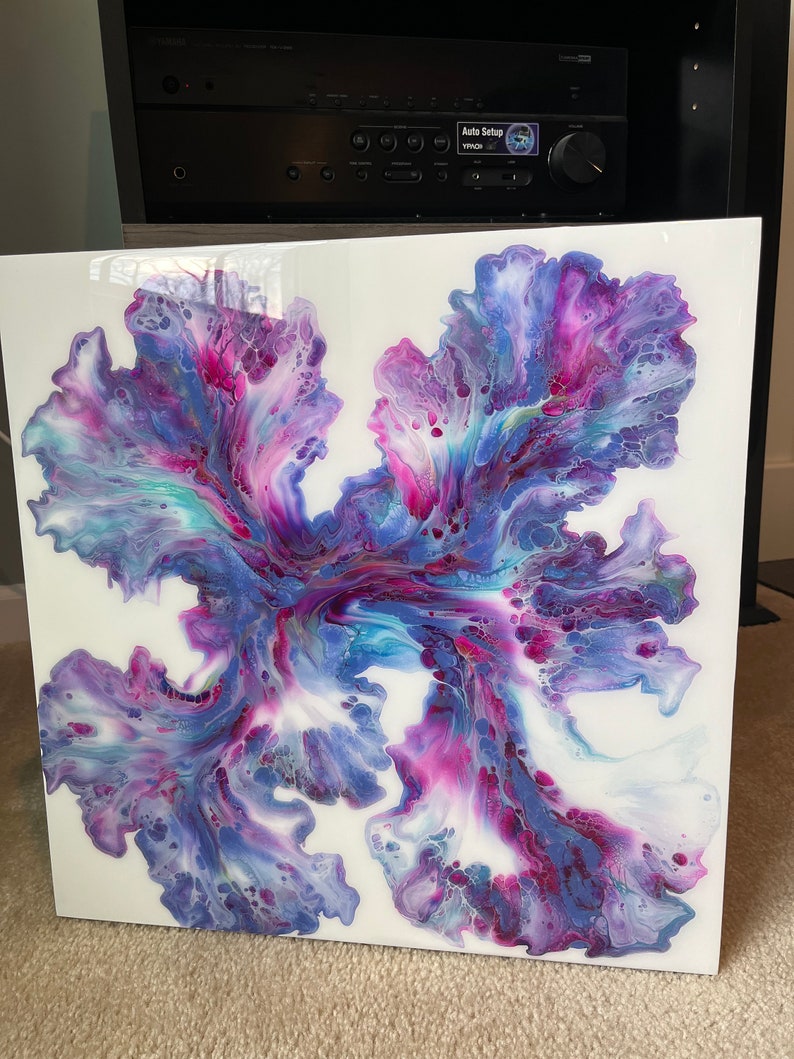 Puede incluir: Pintura abstracta sobre un lienzo blanco con colores que giran en p&uacute;rpura, rosa y azul. La pintura tiene un aspecto fluido y org&aacute;nico.