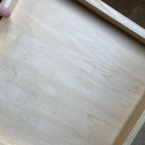 Puede incluir: Un marco de madera claro simple con una superficie de madera clara lisa. El marco est&aacute; hecho de madera sin terminar y tiene una forma rectangular simple.