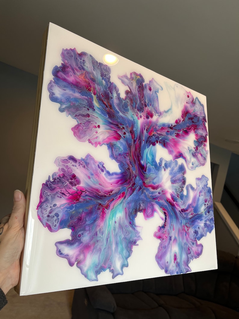 Puede incluir: Pintura abstracta sobre lienzo con colores p&uacute;rpura, azul y blanco que se arremolinan. La pintura tiene un dise&ntilde;o floral sobre un fondo blanco.