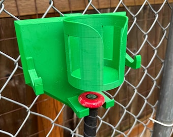 May include: Green 3D printed baseball bat holder with a red knob and a cup holder attached to a chain link fence.