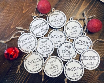 May include: Twelve round, white, wooden ornaments with black text and a wreath design. Each ornament features a different Christian title, such as "Good Shepherd", "King of Kings", "Savior", and "Messiah", along with a corresponding Bible verse.