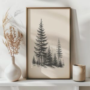 Peut inclure: Une impression encadrée en noir et blanc d'une forêt de conifères. L'œuvre d'art a une esthétique vintage, avec un fond neutre et un cadre simple. L'impression est exposée sur une étagère blanche, créant une ambiance minimaliste.