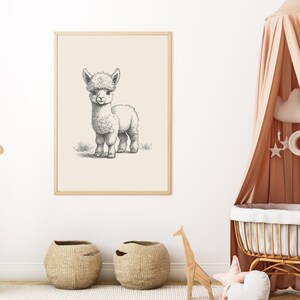 May include: A framed wall art print featuring a black and white pencil sketch of a standing alpaca on a light beige background. The illustration shows the animal in profile with detailed fur texture, positioned within a simple light wood frame.
