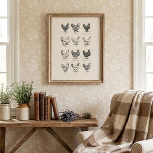May include: A framed print featuring detailed illustrations of various chicken breeds in black and white. The artwork is displayed in a rustic wooden frame, adding a touch of farmhouse charm. The print is mounted on a floral wallpaper background.