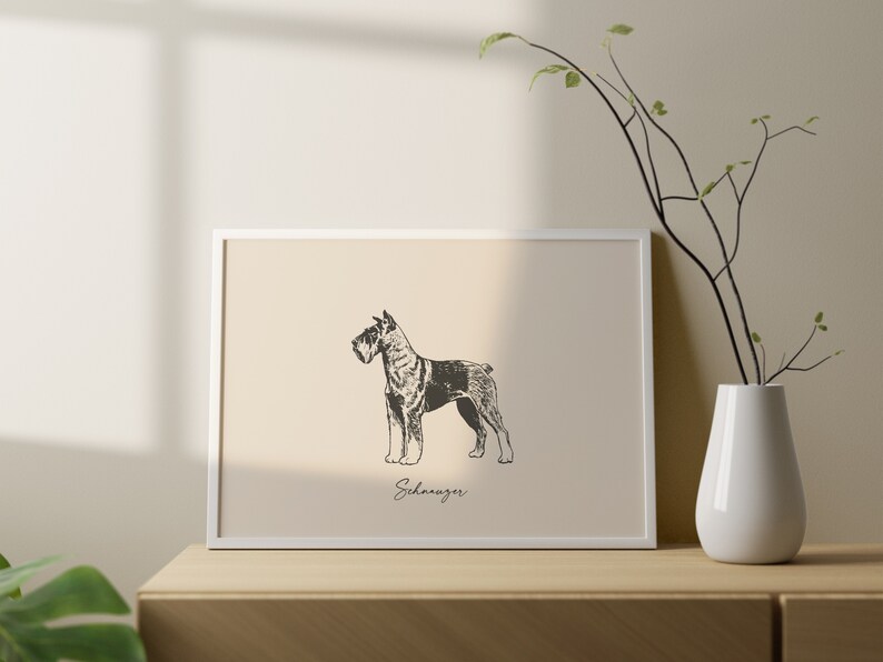 May include: A rectangular white frame containing a beige print with a black and white sketch of a Schnauzer dog in profile. The word Schnauzer is written in a cursive script font below the dog illustration within the frame.