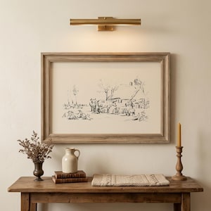 Vintage pencil sketch of farm landscape with horses, sheep and farmer near thatched cottage with bare trees on cream background displayed in rustic oak wooden frame with brass picture light in elegant farmhouse hallway with antique console table, ceramic jug, dried botanicals, wax candle on wooden candlestick and linen knit throw — vintage farmhouse wall art digital download, perfect for rustic home decor, farm animal wall art, countryside living room or farmhouse gallery wall