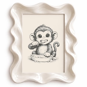May include: A framed print with a monochrome illustration of a monkey brushing its teeth. The monkey is depicted seated, holding a toothbrush over a bowl. The white frame has a wavy, decorative edge.