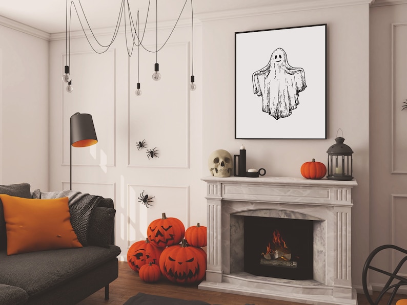May include: A white living room decorated for Halloween with a fireplace, a couch, a black lamp, and a framed drawing of a ghost. There are orange pumpkins with carved faces and black spider decorations on the wall.