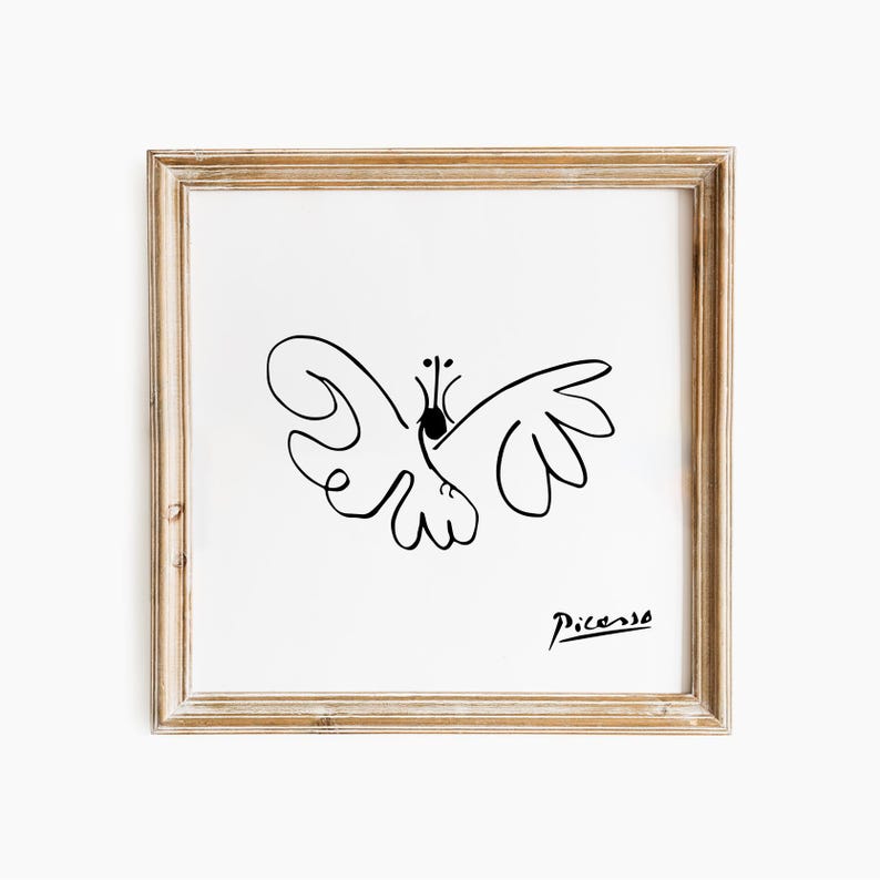 May include: A framed print with a black line drawing of a butterfly on a white background. The artwork is signed "Picasso" in black script. The frame is a light brown colour.
