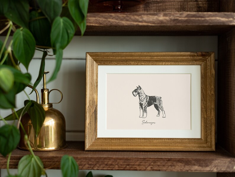May include: A rectangular wooden frame containing a print of a black and white Schnauzer dog illustration on a light beige background. The word Schnauzer is printed in a cursive script font directly below the dog illustration within the frame.