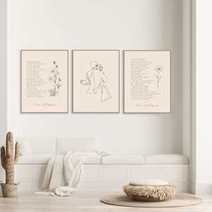 May include: Three rectangular wall art prints in light wood frames. The left print features text and a floral line drawing. The center print shows a continuous line drawing of two figures embracing. The right print displays text and a single flower.