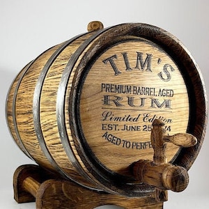 May include: A wooden barrel with a metal tap, labeled "TIM'S PREMIUM BARREL AGED RUM Limited Edition EST. JUNE 25'14 AGED TO PERFECTION".