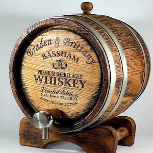 May include: A personalised wooden barrel with metal bands, engraved with "Braden & Brittany Bassham", "Premium Barrel Aged Whiskey", "Limited Edition Est. June 24, 2021", and "Aged to Perfection".