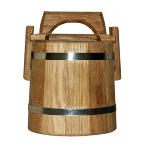 May include: A wooden bucket with a metal band and a handle. The bucket is made of light brown wood and has a natural finish.