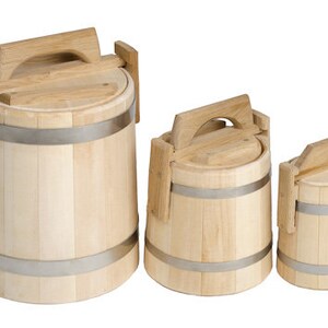 Puede incluir: Tres cubos de madera con tapas y asas. Los cubos son de madera clara y tienen bandas de metal plateado alrededor.