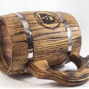 May include: A wooden beer stein with a metal band and a handle. The stein is decorated with a black and white image of a bearded man with the text "Justin Abides".