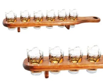 May include: Two wooden serving trays, each holding six shot glasses filled with amber liquid. The glasses are clear with a textured design. The trays are made of light brown wood and have a handle.