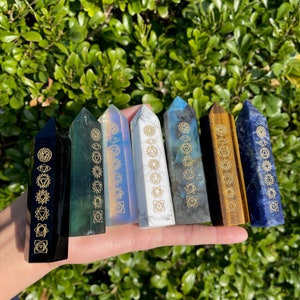 Peut inclure: Sept baguettes de cristal de chakra avec des symboles dorés. Les baguettes sont noires, vertes, irisées, blanches, grises, brunes et bleues.