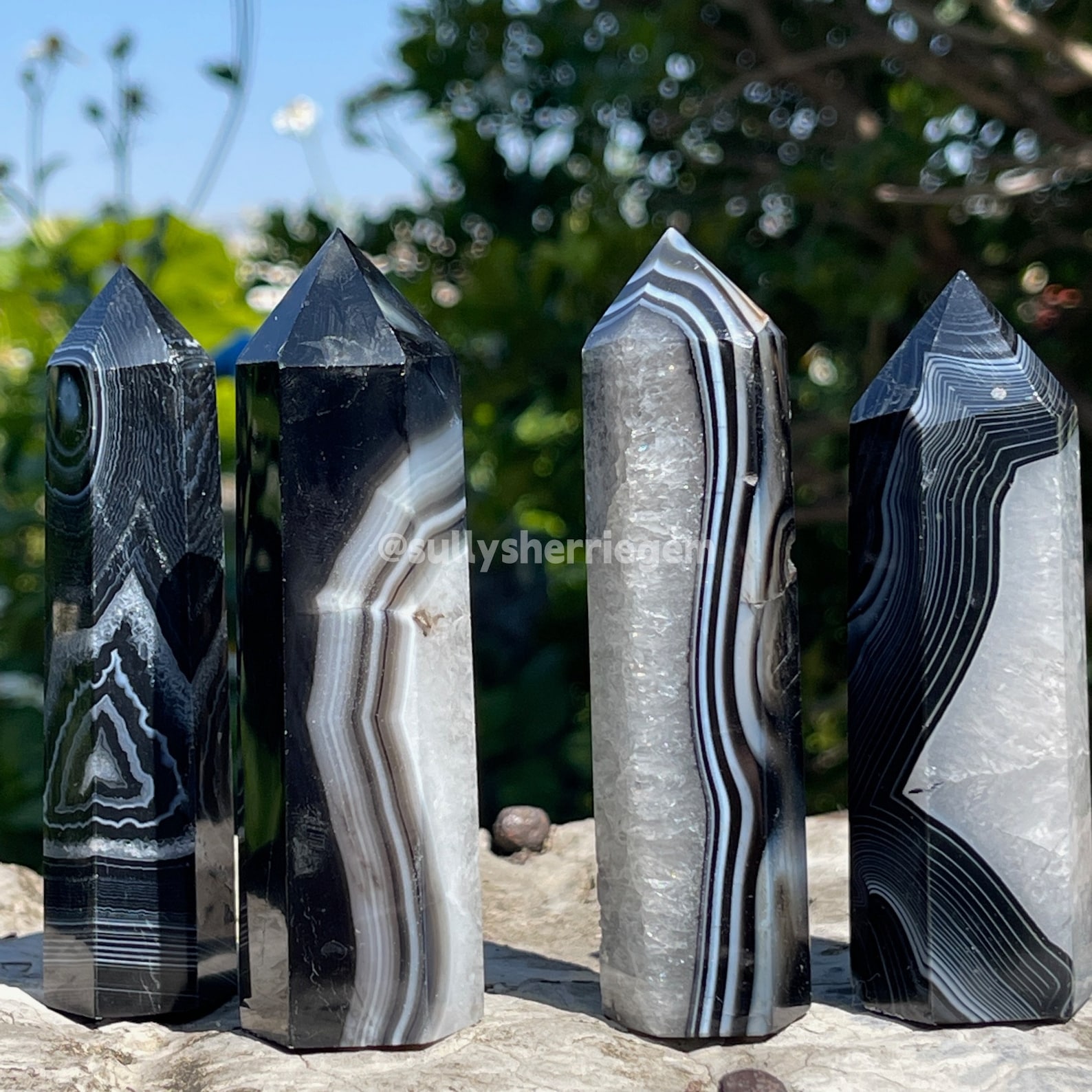Black Onyx crystal towers standing on a stone surface, providing stability and inner strength for Leo.