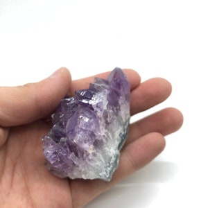 May include: A cluster of amethyst crystals with a deep purple color. The crystals are arranged in a pointed formation, creating a unique and eye-catching display.