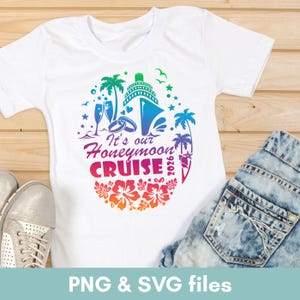 May include: White t-shirt with a colorful graphic design. The design includes a cruise ship, palm trees, champagne glasses, and the text "It's our Honeymoon Cruise 2026". The shirt is paired with denim shorts and silver sneakers.
