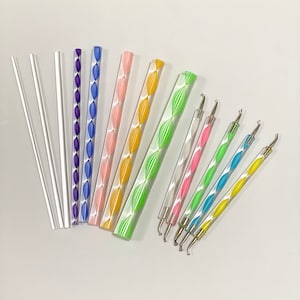 May include: A set of 11 tools for nail art, including clear acrylic sticks and tools with colorful striped designs and metal tips.