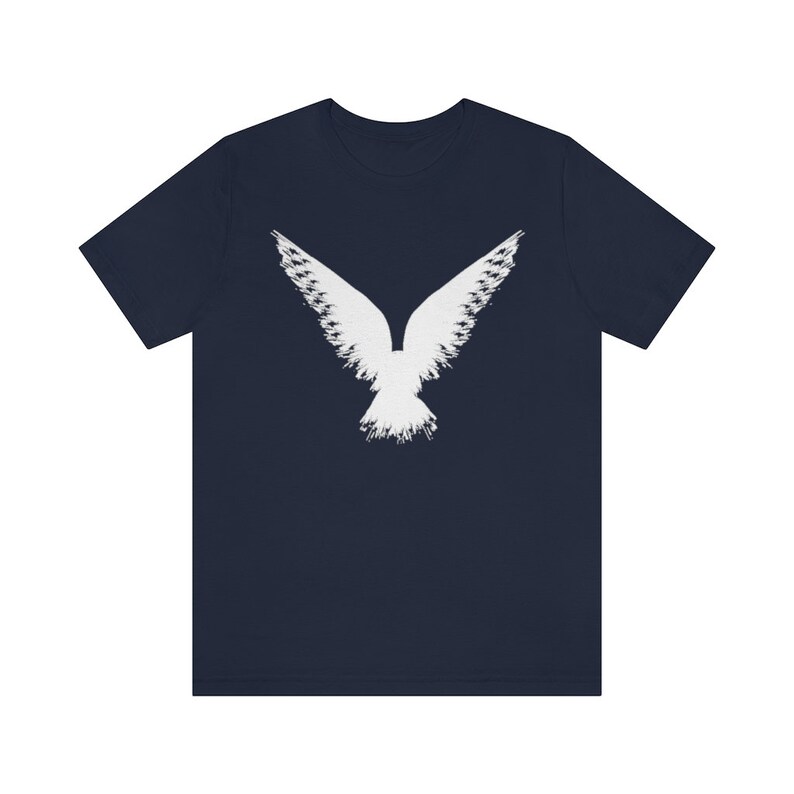 May include: A navy blue t-shirt with a white stylized image of a bird with its wings spread.