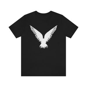 May include: A black t-shirt with a white silhouette of a bird with its wings spread out.