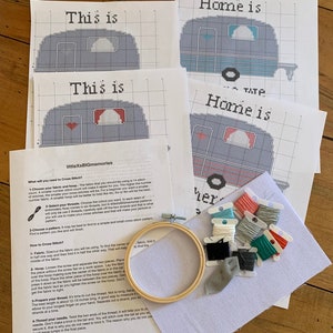 May include: Cross stitch kit with instructions, fabric, embroidery floss, and a wooden hoop. The kit includes two patterns for a camper with the text "This is" and "Home is".