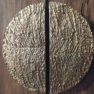 May include: A pair of gold-toned, half-circle cabinet door pulls with a textured, wood-grain design.