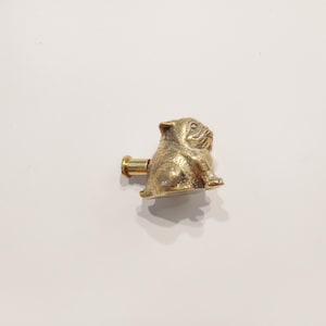 May include: A gold-toned metal cabinet knob shaped like a sitting pug dog.