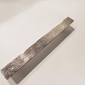 May include: A silver, textured, rectangular cabinet pull.