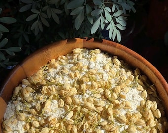 May include: A wooden bowl filled with white powder and dried jasmine flowers.