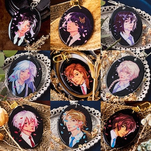 Peut inclure: Dix porte-clés colorés représentant des personnages de style anime avec des couleurs et des styles de cheveux différents. Chaque porte-clés est un pendentif circulaire avec un fond noir et des pétales de fleurs blanches. Les personnages portent des tenues différentes et ont des expressions faciales uniques.