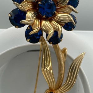 Beautiful blue rhinestones  gold tone flower brooch.