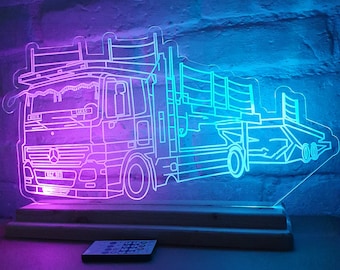 May include: A white acrylic light-up truck with a blue and purple glow. The truck has a flatbed and a ramp. The light-up truck is on a white base and has a remote control.