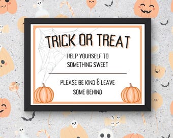 May include: A black framed sign with the text "Trick or Treat" in white. The sign also includes the text "Help yourself to something sweet. Please be kind & leave some behind."  The sign is decorated with a spider web and two orange pumpkins.