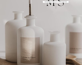 May include: Three white ceramic bottles with labels. The center bottle has a silver top and a label that reads "huile de tournesol". The bottles are sitting on a brown burlap surface. The text "M S MADE MOISELLE S'ORGANISE" is in the top right corner of the image.