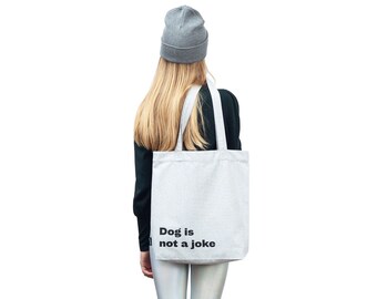 Grey tote bag with a printed slogan Dog Is Not A Joke | Creative gift for Dog lovers