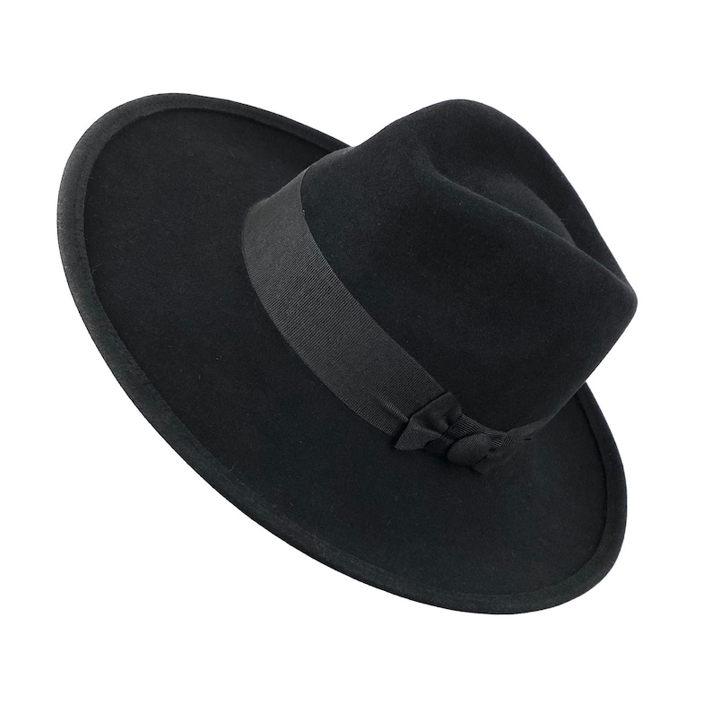 K&ouml;nnte beinhalten: Ein schwarzer Fedora-Hut mit breiter Krempe und schwarzem Band.