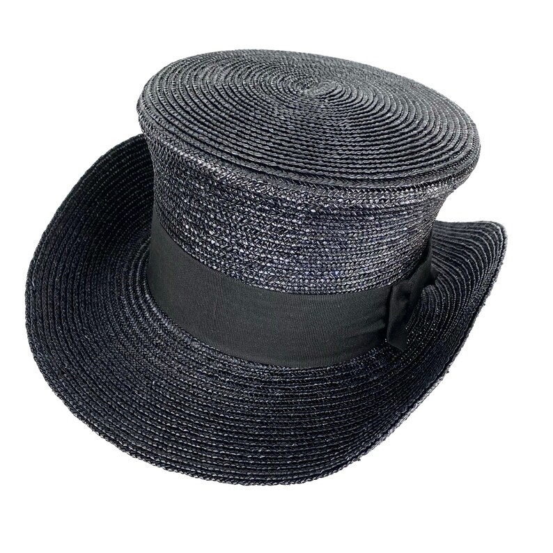 May include: A black straw top hat with a black ribbon around the crown.